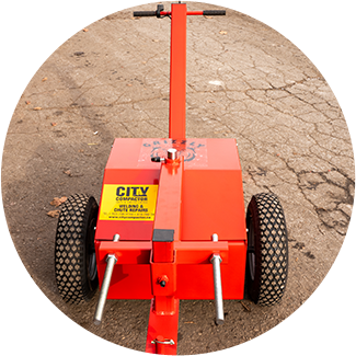 A red cart with wheels and a yellow sign on it.